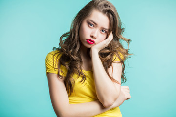Studio portrait of beautiful young woman thinking and looking at camera. Sad girl wants something