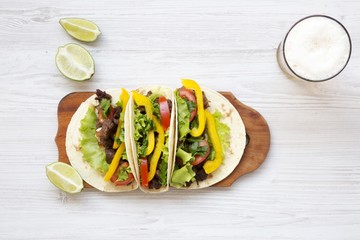 Beef tacos with salad, tomato and beer. Copy space. From above.