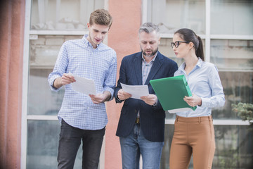 
a group of businessmen discussing business plans on the street
