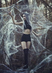 Beautiful sexy Gothic girl with pale skin and long white hair like spider black widow in spider...