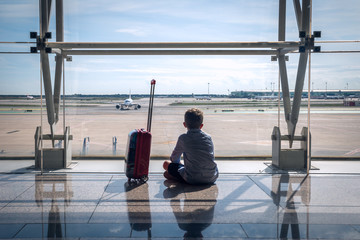 a child at the airport looking at the runway with aircrafts