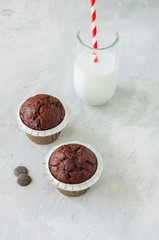 Rich chocolate zucchini muffins with chocolate chips. Close up. White stone background.