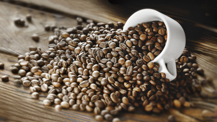 Naklejka premium Coffee beans are poured from a Cup on a wooden background. Copy space for text. Dark background.