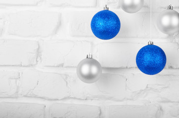 Christmas blue and silver balls on white brick wall holiday background