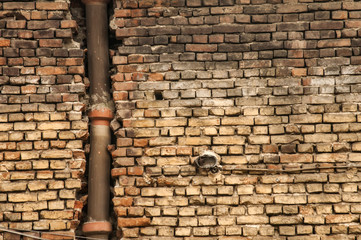 Old grunge weathered brickwall with stoneware vitrified clay ceramic drain sewer pipe closeup