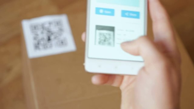 Scanning QR code with smart phone. The man reads the bar code using the application on the smartphone.