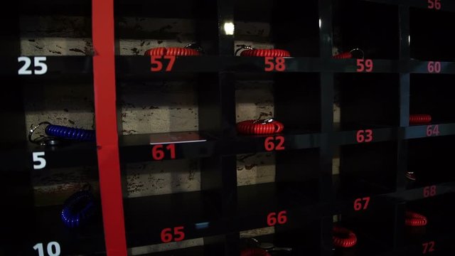 In storage room staff places keys to the cells in place. In sports club, after visiting client class staff returns to shelf red bracelet with a key fob.