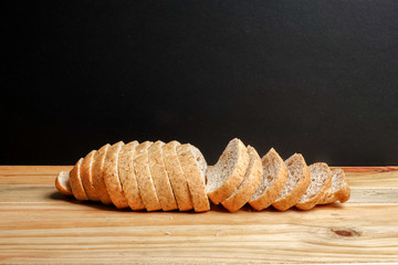 A loaf of wholegrain bread on a wooden background