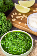 Pesto made from kale, cheese grana padano, lime, pine nuts and garlic - close up  - vertical.