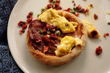 Bacon and egg close up with tomatoes and spring onions.