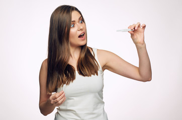 Shocked young woman holding pregnant test.