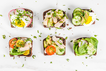 Set of various danish open sandwiches Smorrebrod with fish, egg and fresh vegetables, white marble background copy space top view