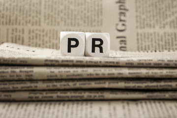 Abbreviation PR on newspapers background