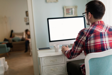 Young handsome designer working on project on computer