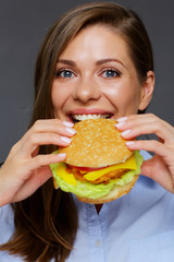 portrait of hungry woman eating burger.