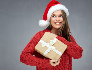 Smiling woman wearing christmas hat holding paper gift box and l