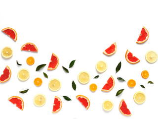 Pattern of fresh fruits on a white background, top view, flat lay.   Composition of green leaves and slices of citrus fruits: grapefruit, lemon, mandarin. Healthy food background, wallpaper, collage.