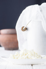 close-up view of fresh healthy cottage cheese and metal bucket behind on wooden table