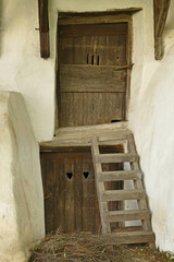 Romania, living quarters in the courtyard of the fortified church Prejmer, wooden doors with hearts and wooden ladder