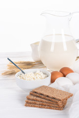 close-up view of crispy crackers, eggs, milk and cottage cheese on wooden table