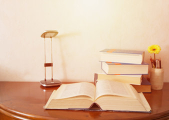 Open book on wood desk with blurred soft focus for education background and back to school concept, vintage tone style.