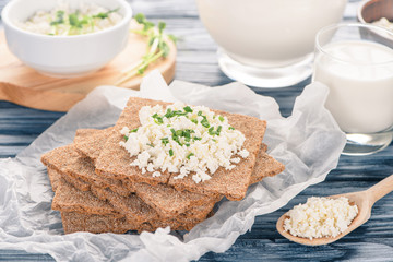 close-up view of crackers with cottage cheese on wooden table