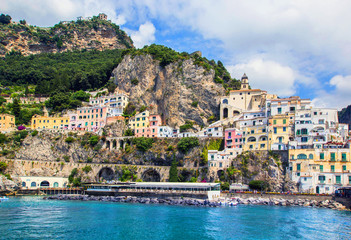 Fototapeta na wymiar Wonderful Italy. Small haven of Amalfi village with turquoise sea and colorful houses on slopes of Amalfi Coast with Gulf of Salerno, Campania, Italy.