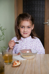 girl  in   kitchen and eating oatmeal.