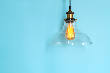 Lamp incandescence in a modern glass ceiling on a blue background. Edison the lamp.