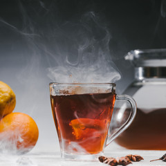 Steaming cup of spicy black tea with lemon
