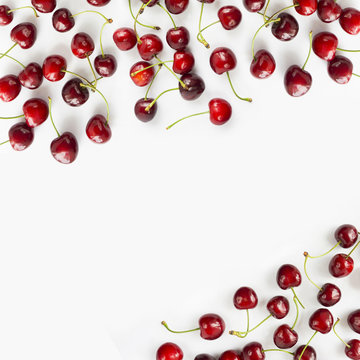 Fresh red cherries lay on white isolated background with copy space for text. Background of cherries. Ripe cherry on a white background. Top view. 