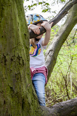 Young girl climbing on a tree