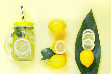 Summer lemon composition for cooking detox lemonade with mint and ice in mason jar on yellow....