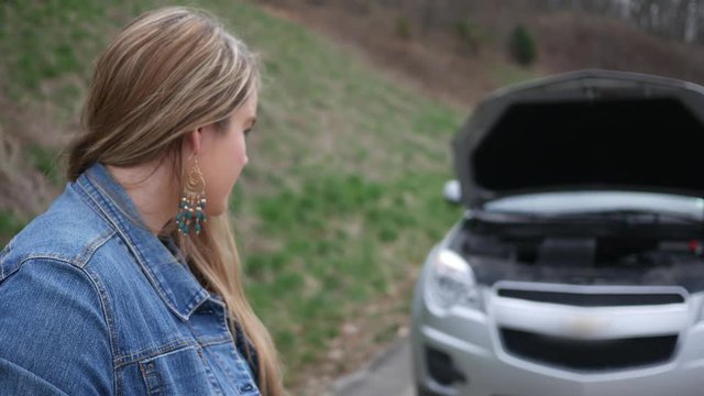 Close up of unhappy woman with car problems on the side of the road