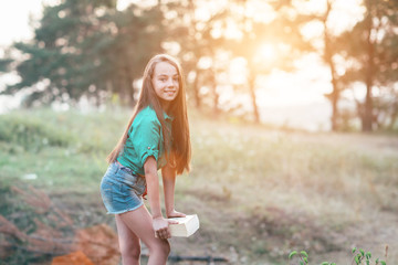 Cute little girl sitting on the grass and reading a book in the