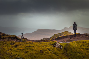 Man In Rain Jacket Looking Into The Distant Landscae From Top of Scottish Mountain