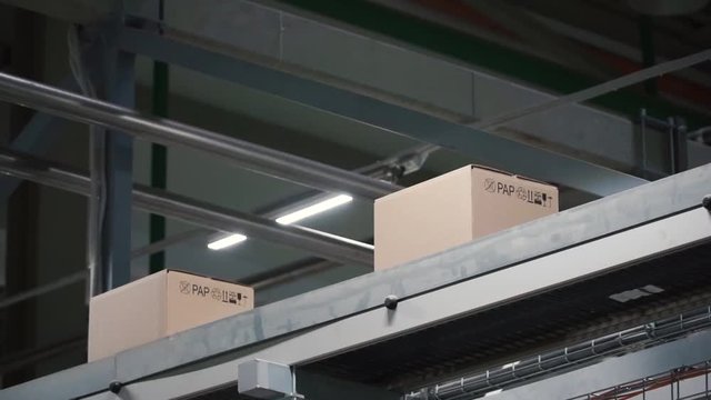 Automation - Cardboard boxes on conveyor belt in factory. Clip. Boxes moving on the conveyor at the factory