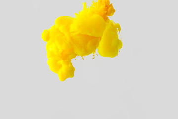 close up view of bright yellow paint splash in water isolated on gray