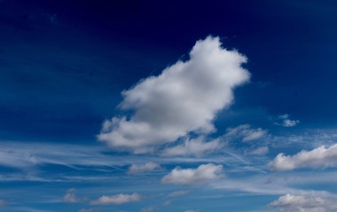 Naklejka na ściany i meble The white puffy cloudscape in the blue sky.