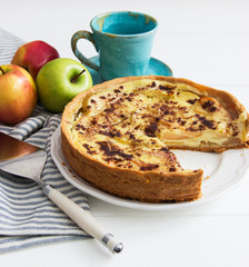 Apple tart crumbly pie crust spatula white table.
