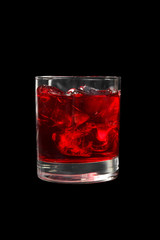 Monochrome transparent cocktail, refreshing in a low glass with a lot of ice cubes with taste of berries, cherries, strawberries, grapefruit. Side view Isolated black background. Drink for the menu