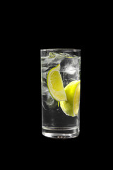 Transparent cocktail in a tall glass with ice cubes with two slices, lime quart, soda, aeration....