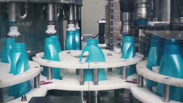 Liquid detergent on automated production line. Clip. Automated production line of washing fluid. Machinery for bottling
