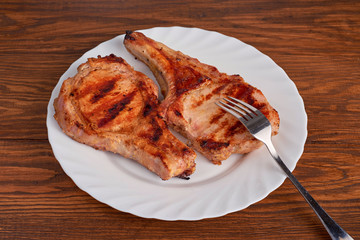 Pork grilled with fresh arugula leaves on a white plate. Top vie