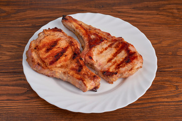 Pork grilled with fresh arugula leaves on a white plate. Top vie