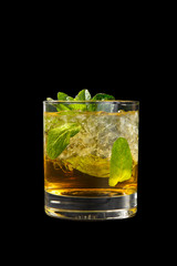 Transparent one-color cocktail in a low glass with crushed ice frappe with mint leaves with melon, pear, apple taste. Side view Isolated black background. Drink for the menu restaurant, bar, cafe