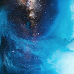 full frame image of mixing blue and black paint splashes in water with universe background