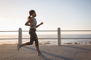 Woman jogging near beach during sunset