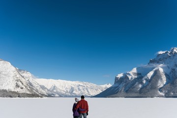Couple standing with arm around in snowy landscape