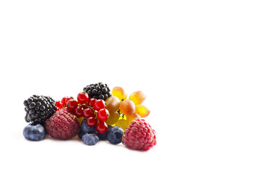 Mixed of fresh fruits and berries isolated on a white background. Ripe blueberries, blackberries, red currants, grapes, raspberries. Background berries.